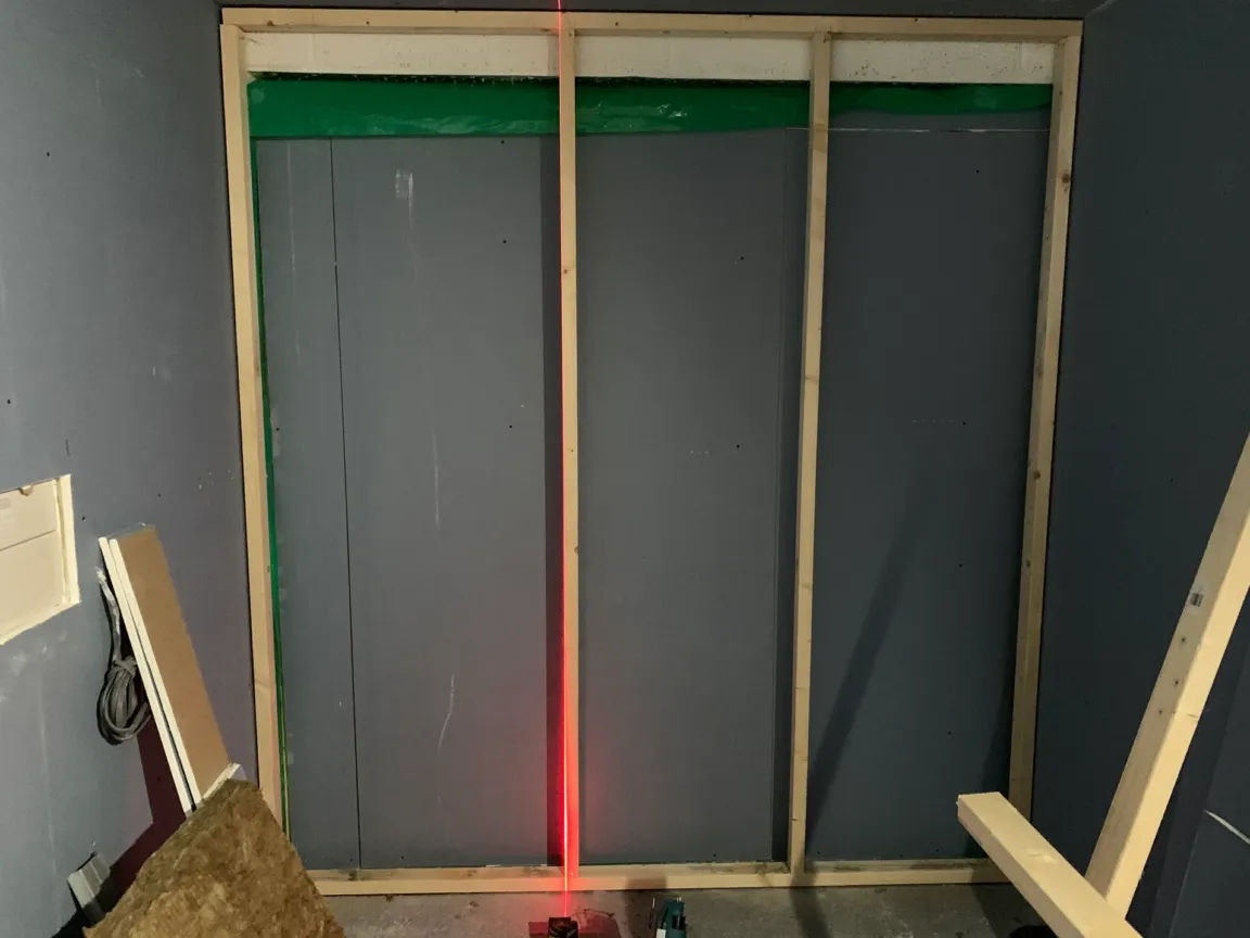 Lazer line showing the straightness of wall joists ready for wall soundproof installation